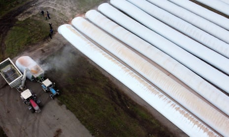 A load of corn is poured into a tractor with grain sleeves, temporary grain storage solution, in the village of Kozyn in Kyiv region, Ukraine November 9, 2022.