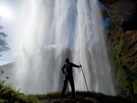 Kevin Rushby standing behind Kiki waterfall.