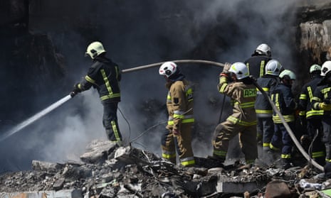 Rescuers work with an active water hose on the rubble of a damaged residential building in Uman, on April 28, 2023, after Russian missile strikes targeted several Ukrainian cities overnight
