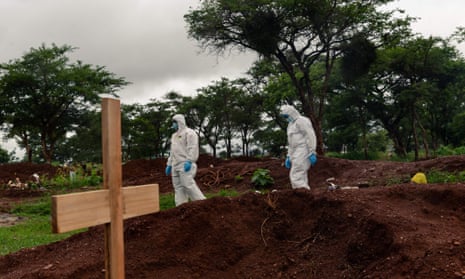 Undertakers in PPE inspect a grave site where a person that passed away due to Covid is to be buried in Zimbabwe.