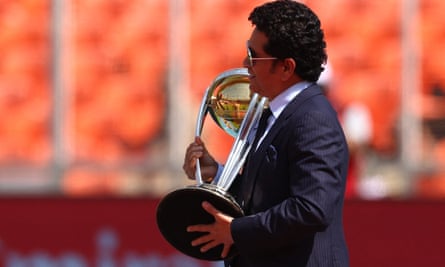 Sachin Tendulkar carries the World Cup trophy on to the field before the match.