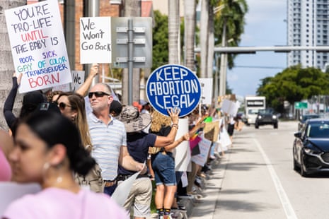 people hold up signs in support of abortion access