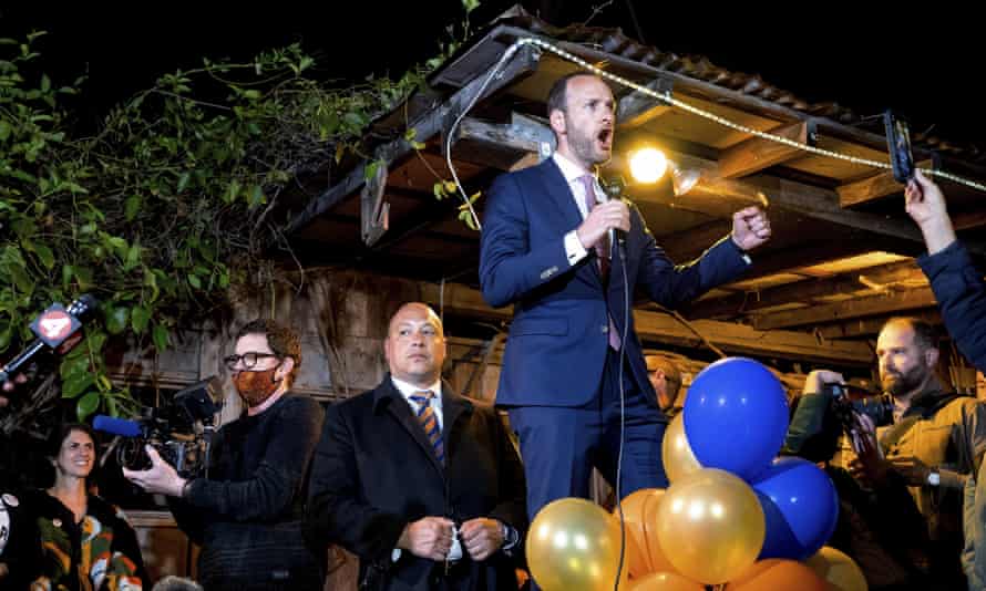 boudin speaks into handheld microphone amid balloons