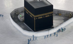 In this 7 March 2020 photo, workers disinfect the ground around the Kaaba, the cubic building at the Grand Mosque, in the Muslim holy city of Mecca, Saudi Arabia.