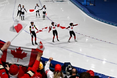 Canadian gold medalists Isabelle Weidemann, Ivanie Blondin and Valerie Maltais celebrate on the ice after their win in the speed skating team pursuit final.