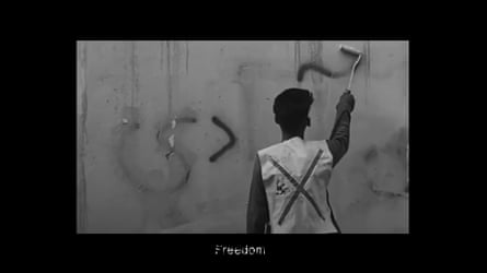 A man paints Freedom on a wall.