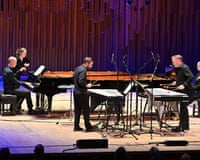 Two men playing vibraphones while facing each other.
