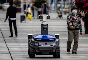 A police security robot drives on the high-speed railway station platform in Shenzhen, Guangdong province. The device, which patrols public places, warns people when they are not wearing masks, checks their body temperature and identity.