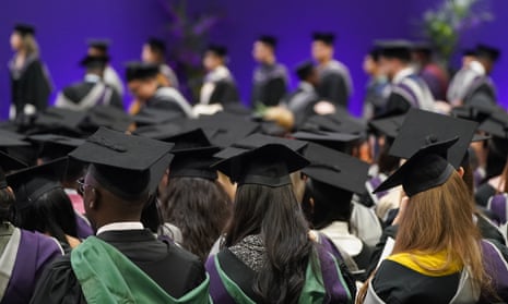 Students wearing mortarboard hats pictured from behind during a graduation ceremony