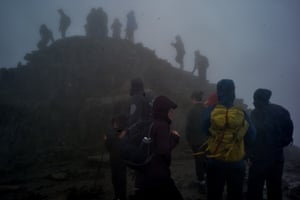 Weary hikers reach the summit of Mount Snowdon.