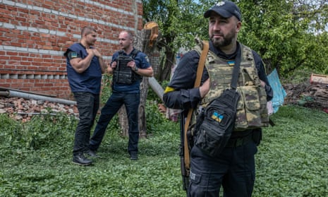 War crimes prosecutors at work in the village of Mala Rohan in the region of Kharkiv