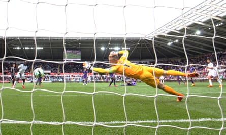 Gylfi Sigurdsson of Swansea City scores a goal past the outstretched Joe Hart of Manchester City.
