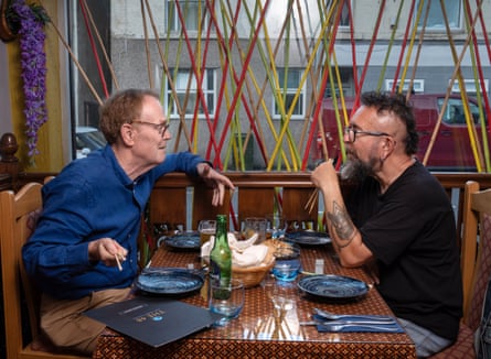 Two men sitting facing each other across a restaurant table