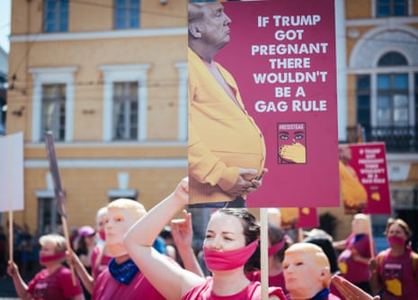 A protester holds a sign reading 'If Trump got pregnant there wouldn't be a gag rule'