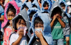 Schoolchildren wear protective padded hoods during an earthquake simulation drill in Japan