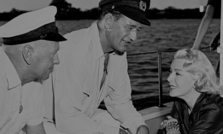 John Farrow, John Wayne and Lana Turner on the set of The Sea Chase in 1955