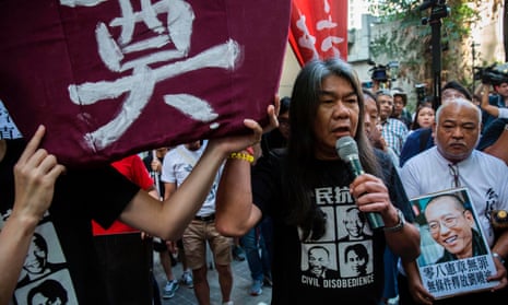 Pro-democracy protester Leung Kwok-hung joins a march in Hong Kong on Saturday. He was later taken away by police.