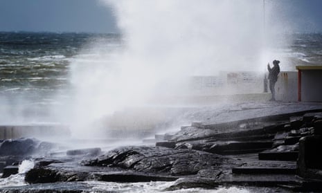 A man taking photos of crashing waves and surf