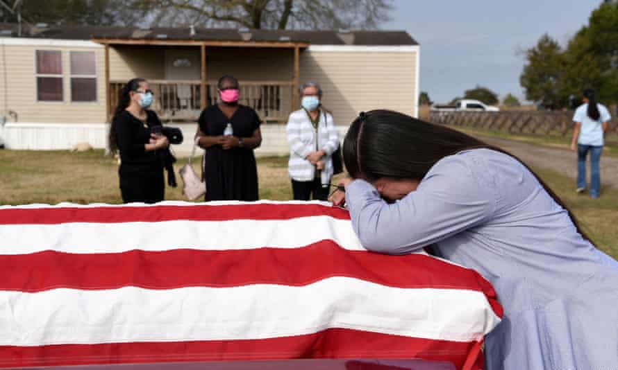 A woman holds the casket of her husband, who died of Covid-19 in San Felipe, Texas.