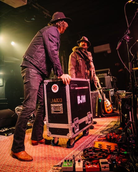 Guitar techs Jordan Blumling (left) and Shea Roberts of The Brian Jonestown Massacre, wheel an equipment case on stage for the evening show at in Brighton, UK.