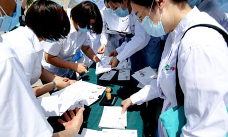 Medical workers attend an event issuing coronavirus-themed stamps on 11 May 2020 in Wuhan, China.