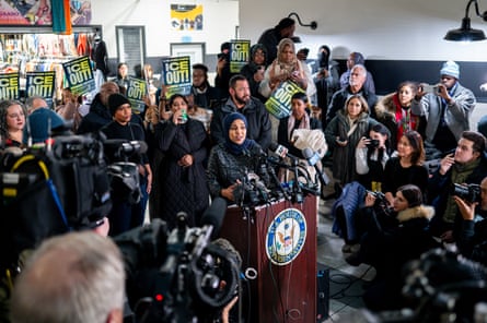 a woman speaks to a crowd of people at a lectern