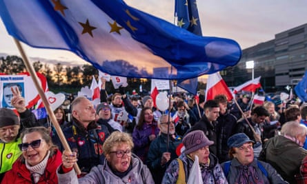 People wave Polish and EU flags