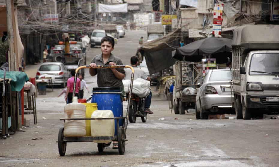 A boy pushes a cart with jerry cans filled with water in Aleppo. Syria where water shortages are thought to have contributed to the start of the civil war