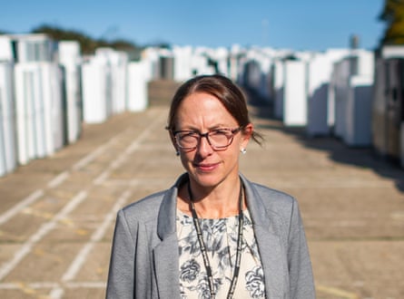 Kate Murrell stands between long rows of discarded white fridges and freezers awaiting recycling