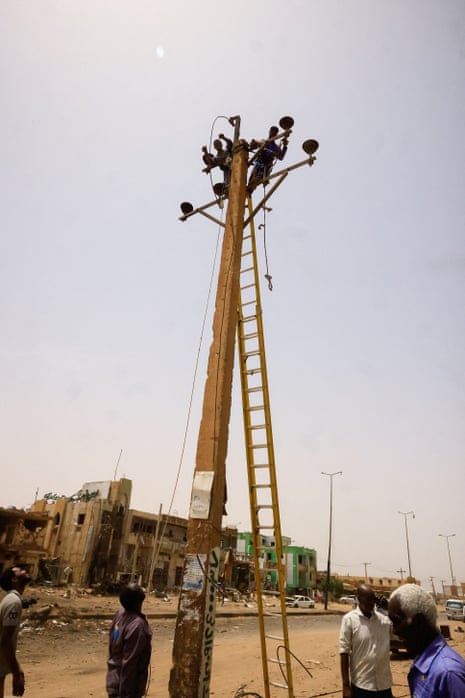 Electricity workers work on the power lines at the central market in Khartoum North.