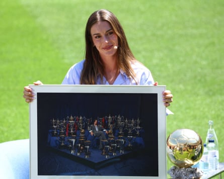 Alexia Putellas poses with a photo of herself surrounded by all of the trophies she’d won while at Barcelona.