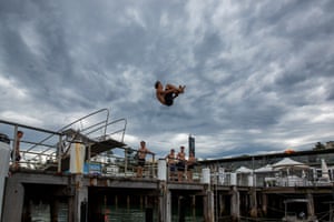 A boy jumps into the water from Manly Wharf in Sydney, Australia