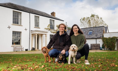 Megan Gay and Sean Wood, on the lawn of a beautiful large house, with three dogs