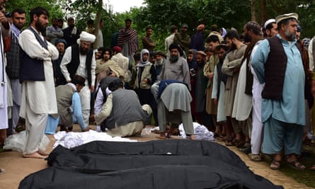 The bodies of Afghans killed in the floods are placed on the ground in Baghlan province, northern Afghanistan