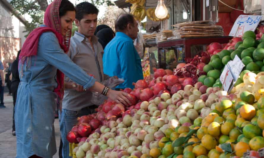 Yasmin Khan choosing pomegranates, the nation’s favourite fruit, at an Iranian market.