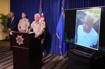 police gather around a podium next to a television monitor during a press conference