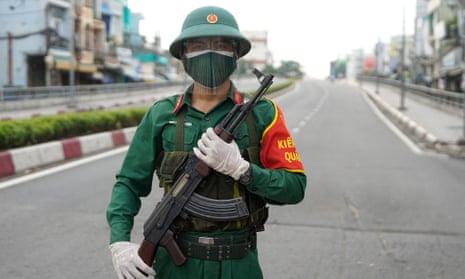 A Vietnamese military personnel stands guard on a deserted road in Ho Chi Minh City, after the government imposed a stricter lockdown to stop the spread of Covid.