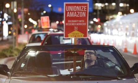 A man holds a sign in support of Amazon workers unionizing in Bessemer, Alabama, in Seattle, Washington, on 20 February.