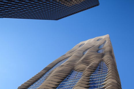a wavy grey skyscraper reaching up into the blue sky