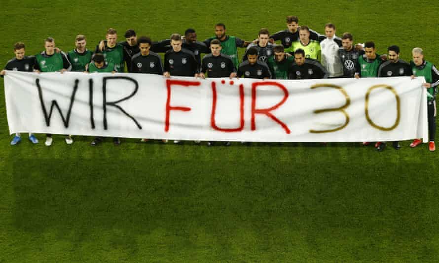 Germany’s squad poses with a “We Support 30” banner, in reference to the UN’s list of 30 human rights, before the game.
