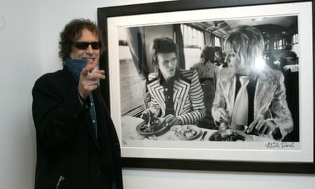Mick Rock with one of his photographs of David Bowie with band member Mick Ronson.