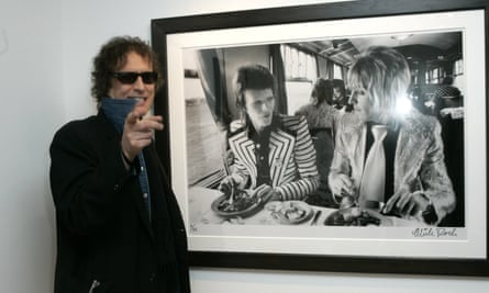 Mick Rock with his famous photo of David Bowie and Mick Ronson on a train.