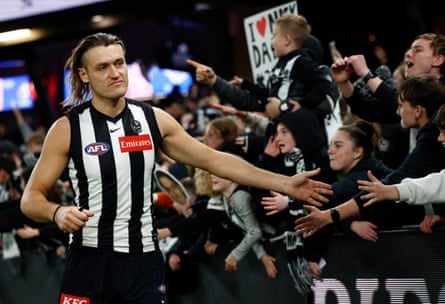 Darcy Moore of the Magpies celebrates with fans