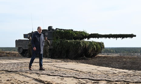 German Chancellor Olaf Scholz walks past a Leopard 2 main battle tank of the Bundeswehr in Ostenholz in October, 2022.
