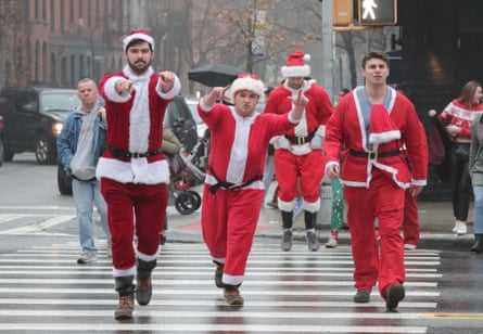 A group of men dressed as Santa Claus cross a street in New York City in 2019.