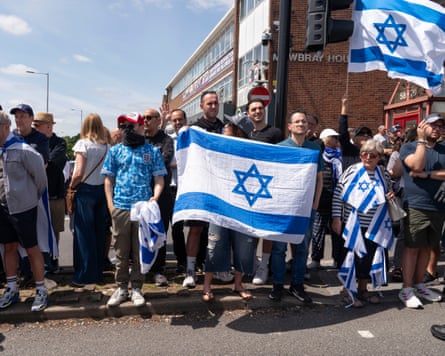 People stock in street holding Israeli flags