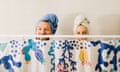 Couple standing behind the shower curtain with towels on their head