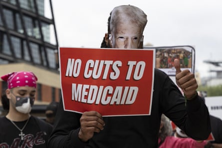 a protester with a sign saying no cuts to medicaid