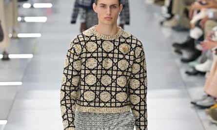 Model walking down runway wearing sweater with cannage pattern