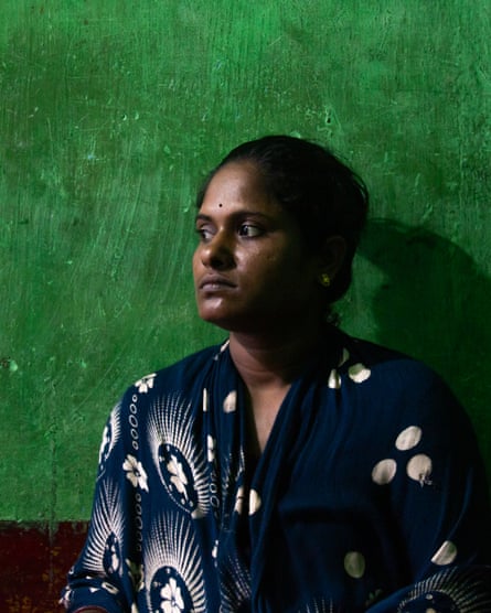 Indian woman with a green wall behind her